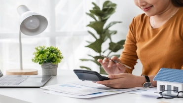 Woman,Calculating,Real,Estate,Transaction,At,Home,Office,Desk,With