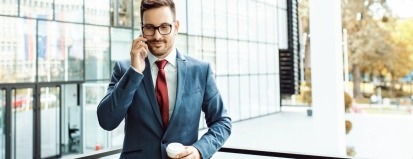 Man met telefoon in de hand en koffie