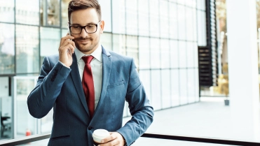 Man met telefoon in de hand en koffie