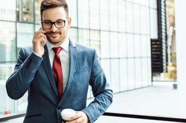 Man met telefoon in de hand en koffie