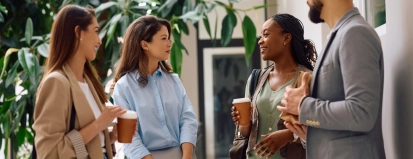 een groepje collega’s praat bij het koffieautomaat