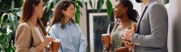 een groepje collega’s praat bij het koffieautomaat