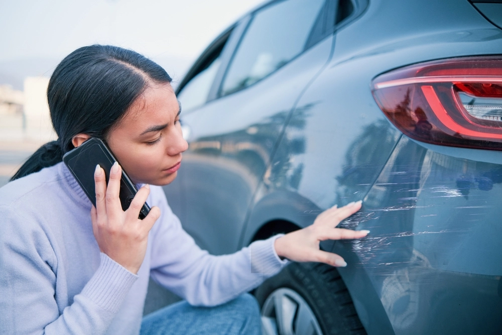 Woman,Calling,Car,Insurance,Examining,Car,Damage
