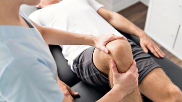 Patient at the physiotherapy doing physical exercises with his therapist